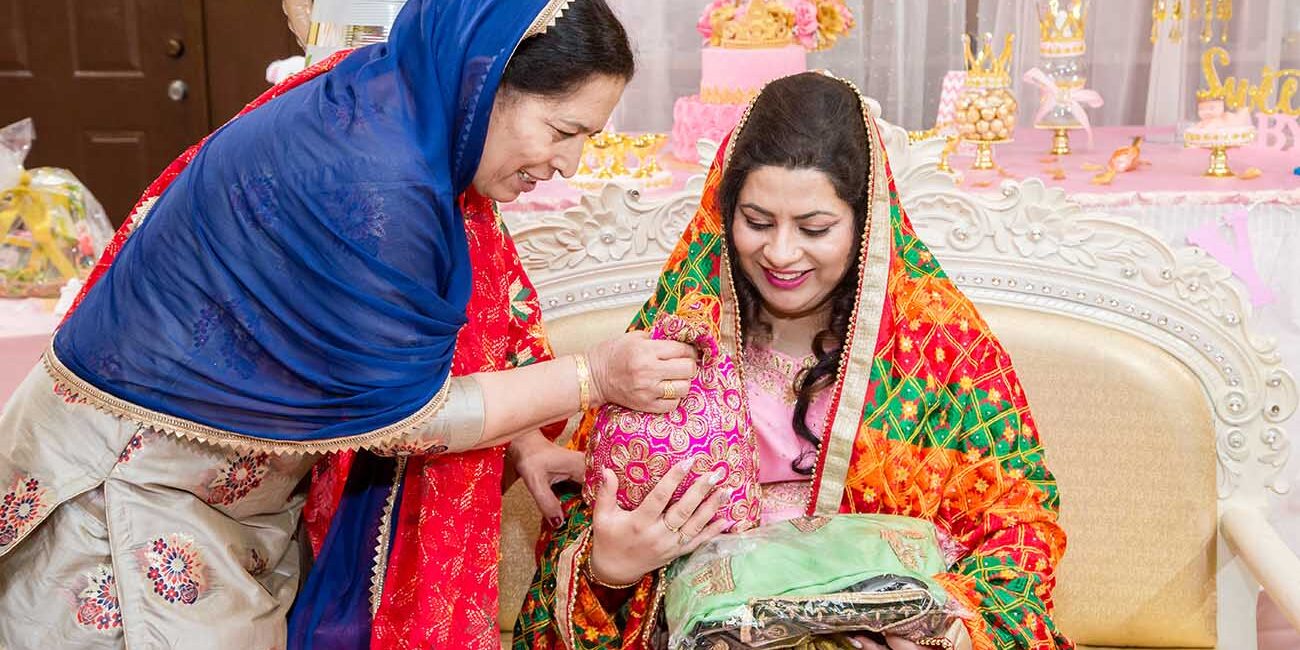 Family celebrating a beautifully decorated baby shower with pink crown-themed cake and décor, captured by Citi Events Productions baby shower photography in Floral Park, New York